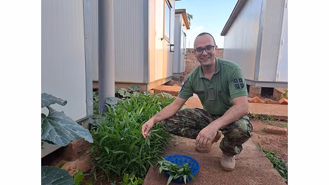 Le capitaine Ljubisav Vicentijevic, officier de la force de maintien de la paix de la République de Serbie, récolte des légumes dans un potager vietnamien. Photo : baoquocte.vn