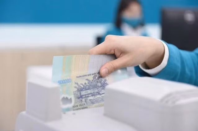 Un caissier de banque compte de l'argent dans un bureau de transaction à Hanoi. (Photo : vietnamfinance.vn)
