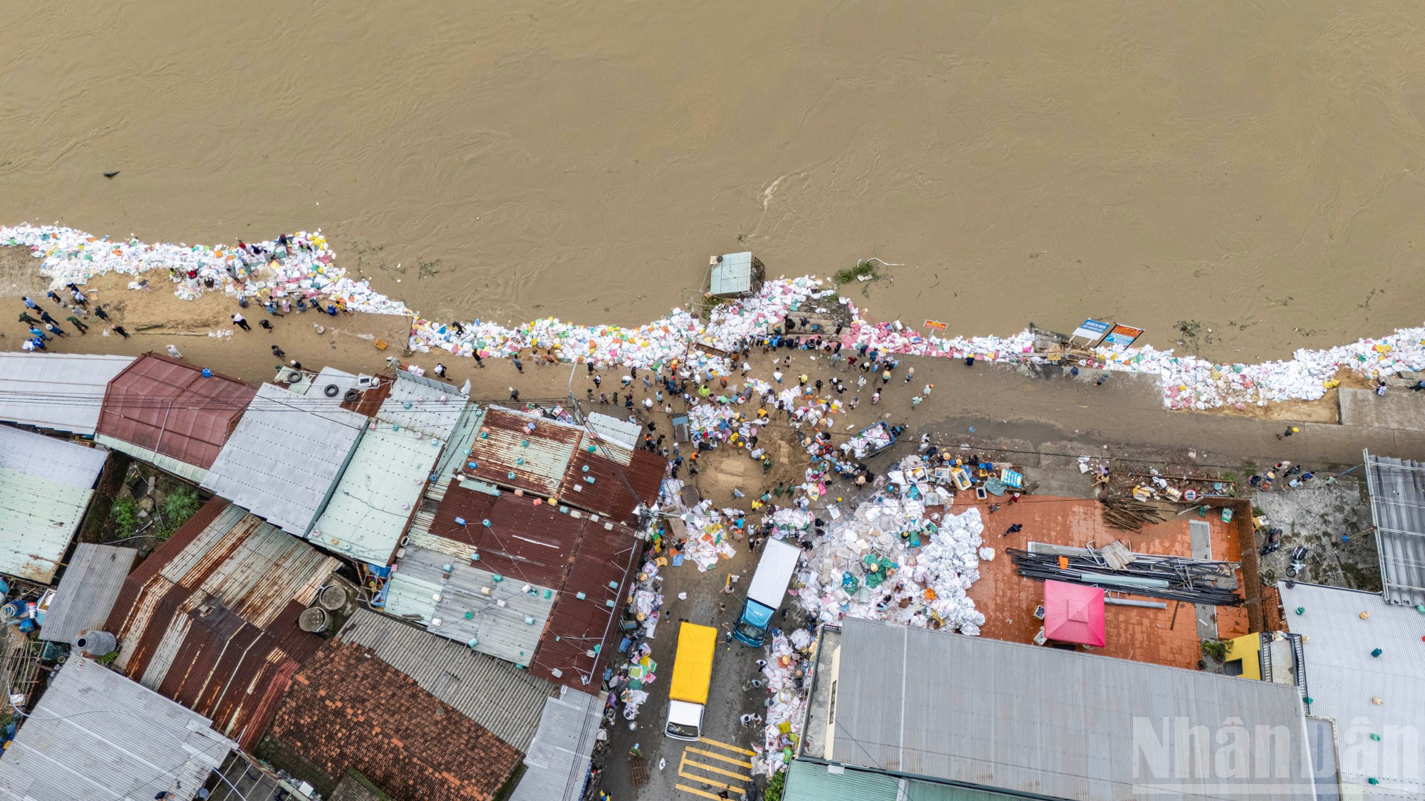 La nouvelle digue de sacs de sable paraît frêle face à la puissance des courants, mais incarne la détermination inébranlable et le courage collectif des habitants de Duy Nghia — un symbole de résilience vietnamienne face aux catastrophes naturelles. Photo : Phan Hai Tung Lam/NDEL