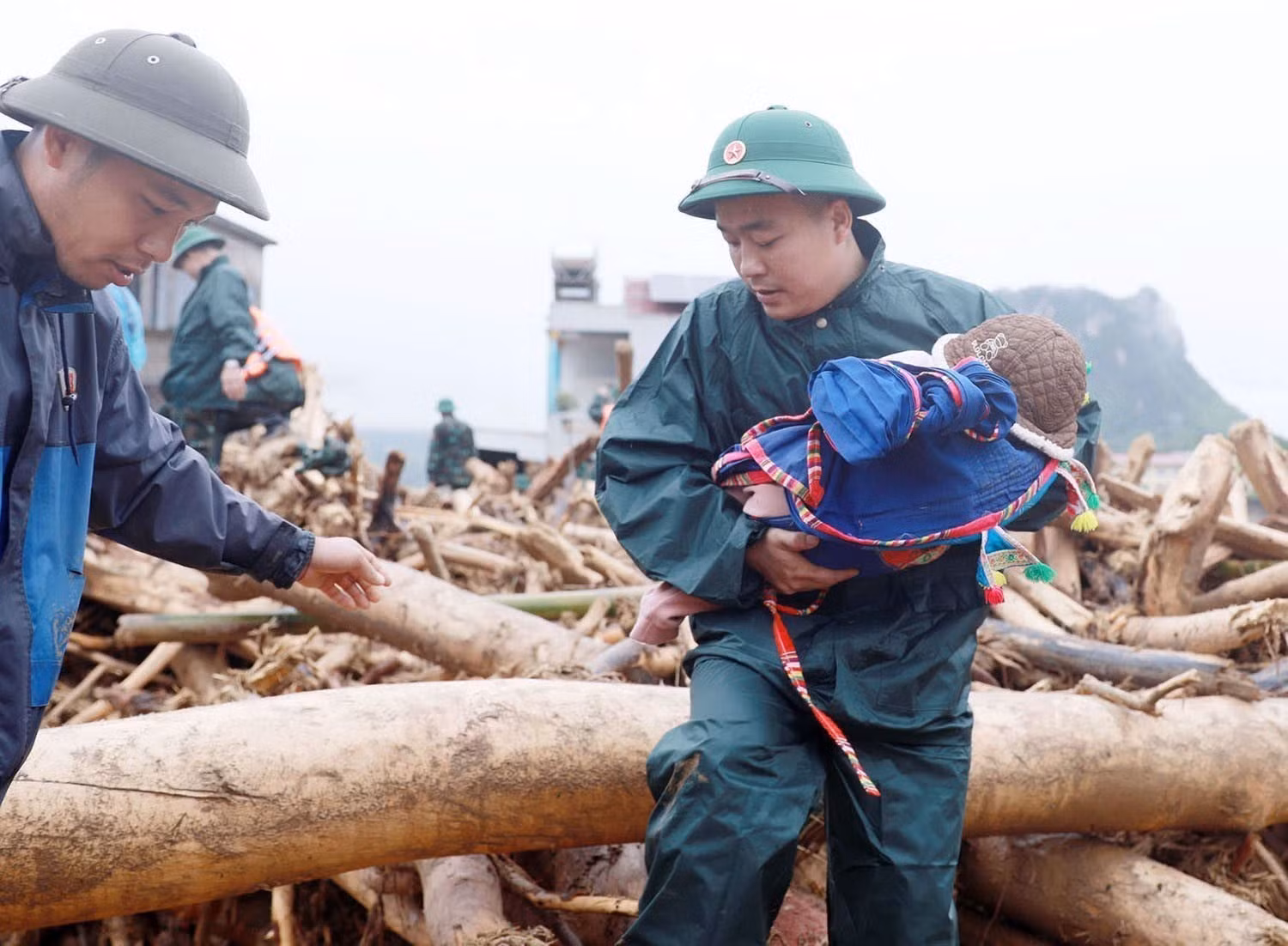 Les forces de milice et d’autodéfense évacuent des enfants hors de la zone dangereuse touchée par les crues soudaines dans la commune de Muong Than, province de Lai Chau. Photo : VNA