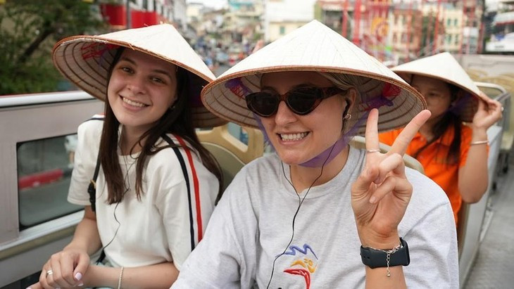 Deux touristes profite du circuit en bus à deux étages proposé par la ville de Hanoï. Photo : nhandan.vn