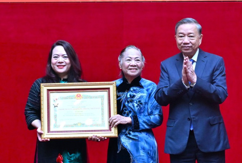 Le secrétaire général du Parti Tô Lâm (droite) remet la distinction à la famille du général Bui Thien Ngo. Photo: TPO.