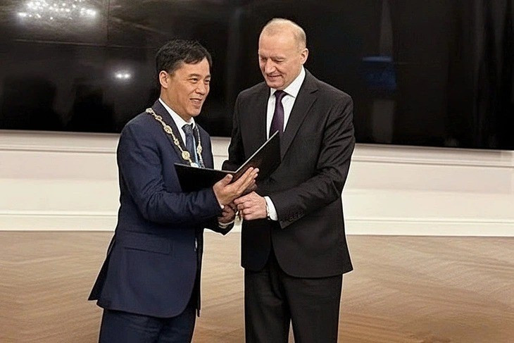 Le président de l’IAAS, académicien de l’Académie nationale des sciences du Bélarus, M. Vladimir Gusakov, remet le diplôme et l’insigne d’académicien de l’Union des académies mondiales des sciences au professeur et académicien Le Truong Giang. Photo : VNA.