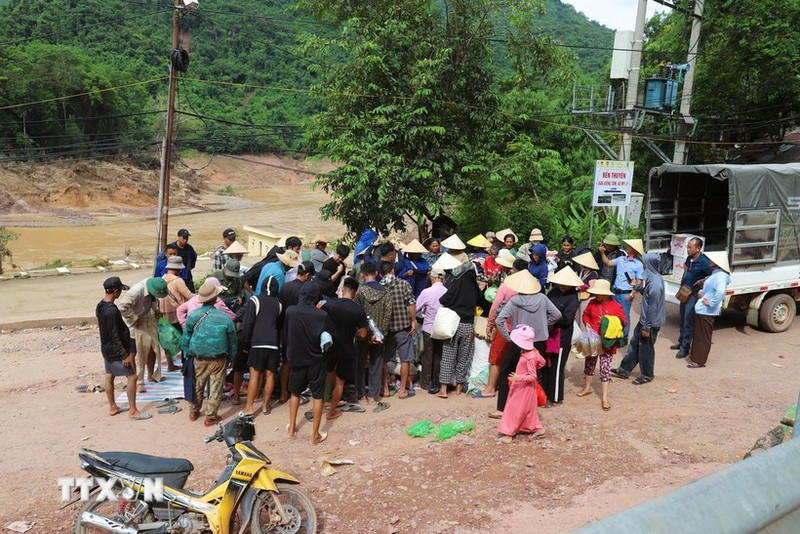Des habitants encore isolés reçoivent des vivres, denrées alimentaires et produits de première nécessité d’actions caritatives au village de Xieng Tam (commune de My Ly, province de Nghe An) avant d’être acheminés en barque vers les hameaux. Photo : VNA.