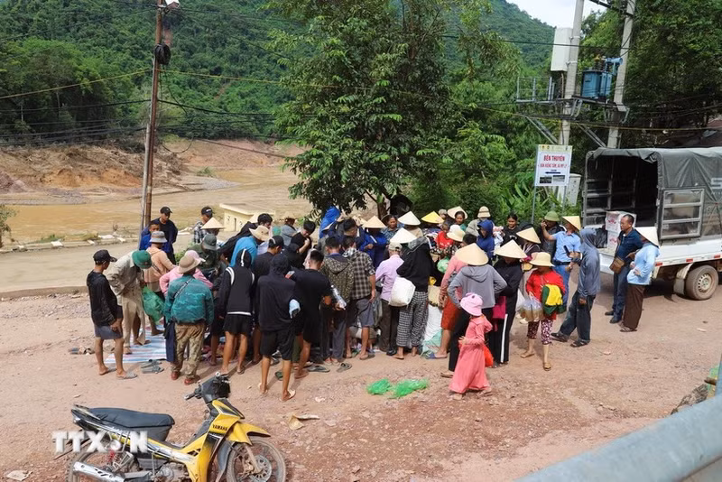 Des habitants encore isolés reçoivent des vivres, denrées alimentaires et produits de première nécessité d’actions caritatives au village de Xieng Tam (commune de My Ly, province de Nghe An) avant d’être acheminés en barque vers les hameaux. Photo : VNA.