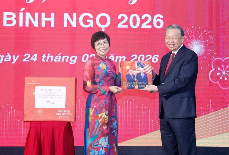 La directrice générale de la VNA, Vu Viêt Trang, remet au secrétaire général Tô Lâm un livre de photos réalisé par les journalistes du Département de rédaction des photos de presse. Photo : VNA.