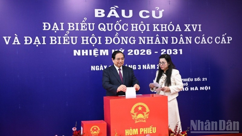 Le Premier ministre Pham Minh Chinh et son épouse déposent leurs bulletins de vote dans l'urne. Photo : NDEL.