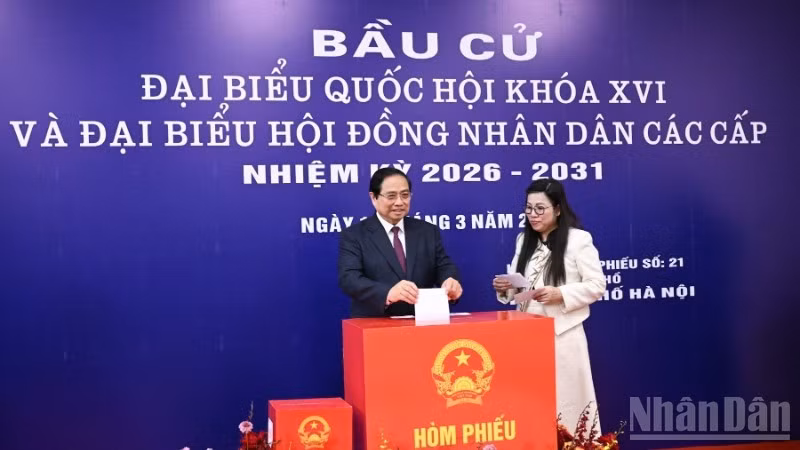 Le Premier ministre Pham Minh Chinh et son épouse déposent leurs bulletins de vote dans l'urne. Photo : NDEL.