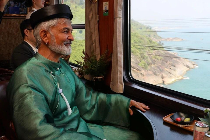 Un touriste étranger, vêtu d’áo dài, a admiré le paysage du col de Hai Van et de la baie de Lang Co à travers la fenêtre. Photo : Znews.