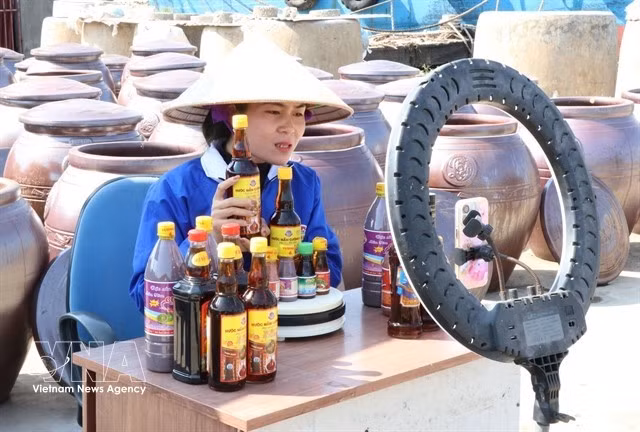Une femme de la province de Ninh Bình diffuse en direct pour vendre des produits locaux. Photo : VNA