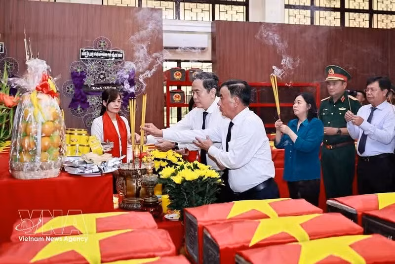 Le président de l'Assemblée nationale, Tran Thanh Man, le membre permanent du Secrétariat du Comité central du Parti, Tran Cam Tu, et d'autres délégués brûlent des bâtonnets d'encens en mémoire des martyrs au dépôt des restes de martyrs. Photo : VNA.