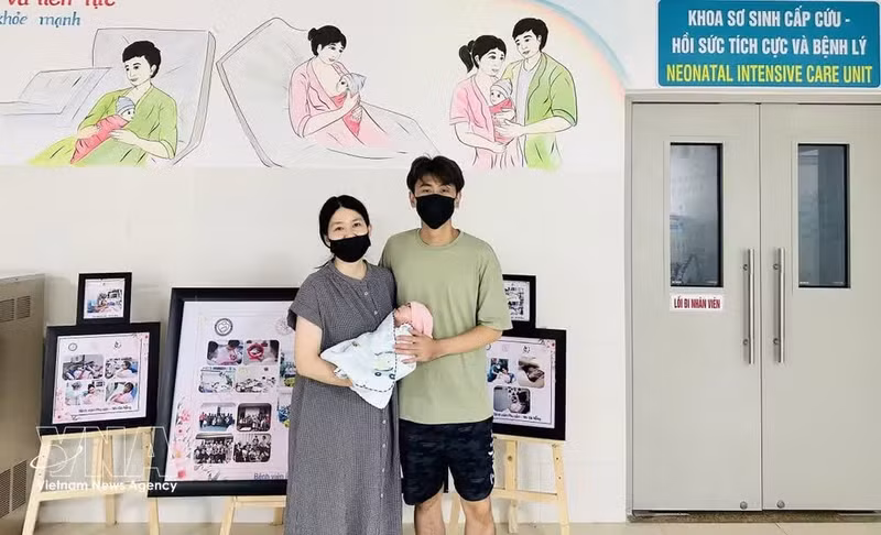 Le couple singapourien et leur bébé le jour de leur sortie de l'hôpital. Photo : VNA