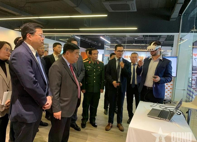 Le vice-Premier ministre Nguyen Chi Dung et les délégués écoutent la présentation du Centre de recherche-développement (R&D) et du Centre d’Excellence consacrés à l’intelligence artificielle et au jumeau numérique. Photo : Quan doi nhan dan