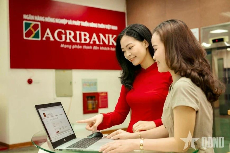 Des employés de la Banque vietnamienne de l’Agriculture et du Développement rural (Agribank) guident les clients dans la réalisation de transactions sécurisées sur les canaux numériques. Photo : Journal Quân đội nhân dân.