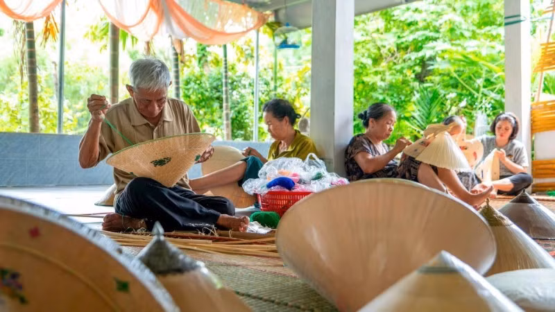 L’Artisan Émérite Do Van Lan brode des motifs décoratifs sur un chapeau conique de Phu Gia. Photo : My Ha.