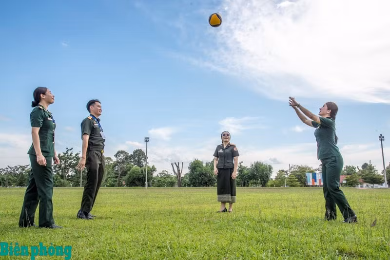 Les jeunes officiers vietnamiens et laotiens échangent quelques gestes techniques dans une ambiance conviviale avant le match officiel de volley-ball. Photo : Le Van Chuong.