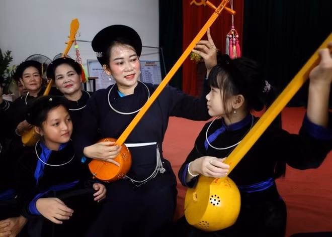 Les enfants apprennent le chant then et le dan tinh (un instrument à cordes traditionnel) au club de chant then et de dan tinh de la commune de Luc Ngan, province de Bac Ninh. Photo : VNA.