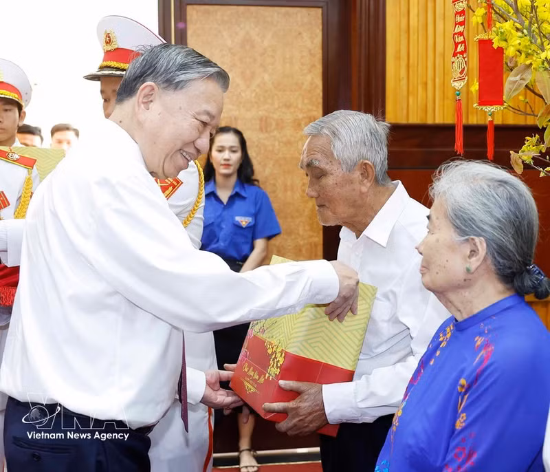 Le secrétaire général To Lam offre des cadeaux aux familles des personnes méritantes. Photo : VNA