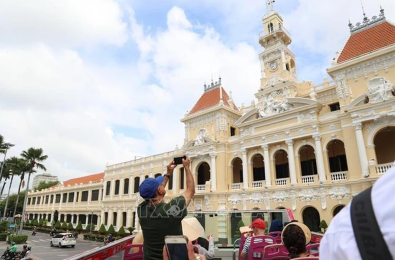 Des visiteurs internationaux explorent le centre-ville d'Ho Chi Minh-Ville à bord d'un bus à impériale. Photo : VNA.