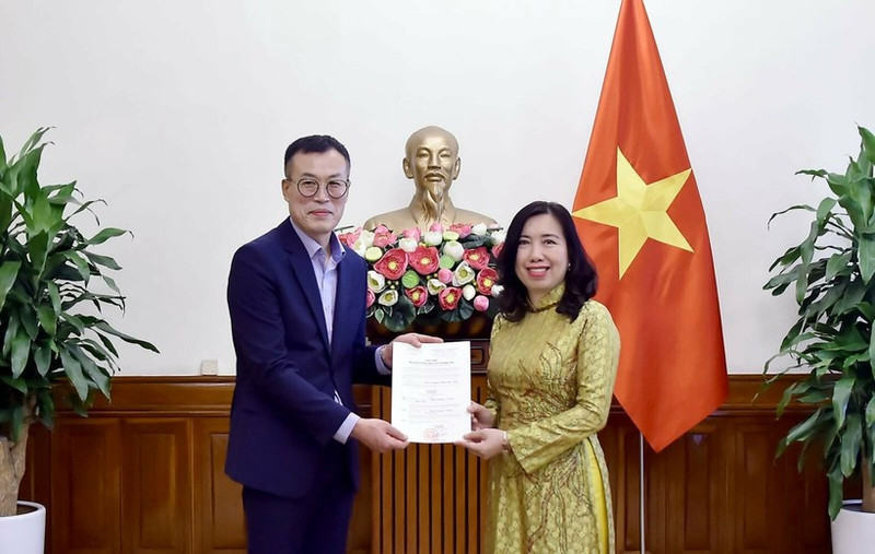 La vice-ministre des Affaires étrangères Le Thi Thu Hang remet la licence à Kim Kwan Woong, chef du bureau et correspondant résident de Financial News au Vietnam. Photo : ministère vietnamien des Affaires étrangères.
