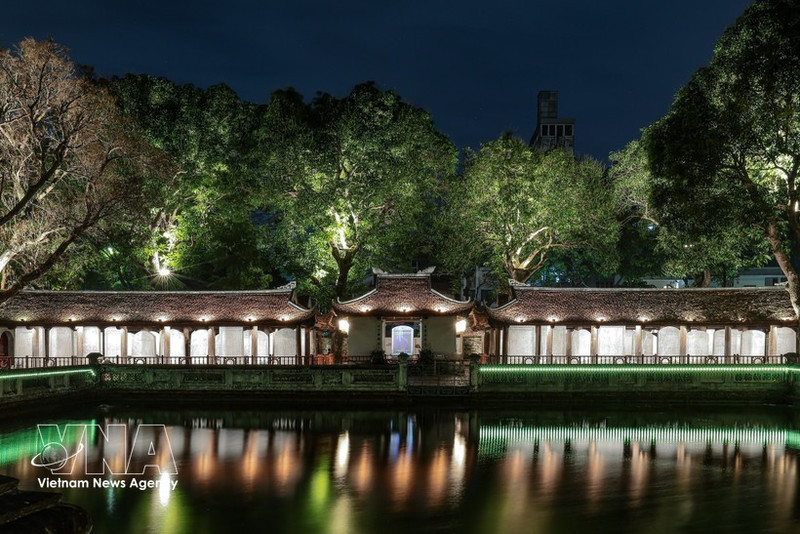 Effets lumineux projetés sur la surface des stèles en pierre et les motifs anciens, mettant en valeur les détails du patrimoine. Photo : VNA.