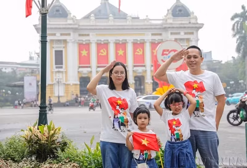 Une famille prend une photo de souvenir à Hanoi à l'occasion du 50e anniversaire de la libération du Sud et de la réunification du pays (30 avril 2025). Photo : VNA.