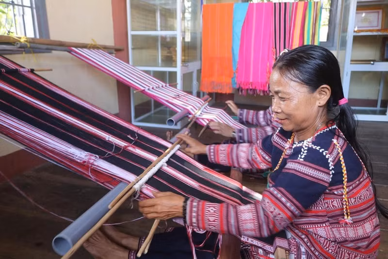 Une femme Ba Na du village de Xi Thoai tisse du brocart traditionnel. Photo : VNA.