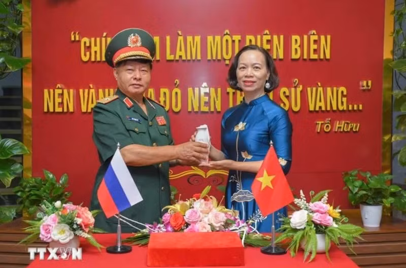 Le général Luu Trong Lu, président de l’Association des anciens combattants de la province de Dien Bien, remet l’urne contenant la terre sacrée à Vu Thi Tuyet Nga, directrice du Musée de la Victoire de Diên Biên Phu. Photo : VNA.