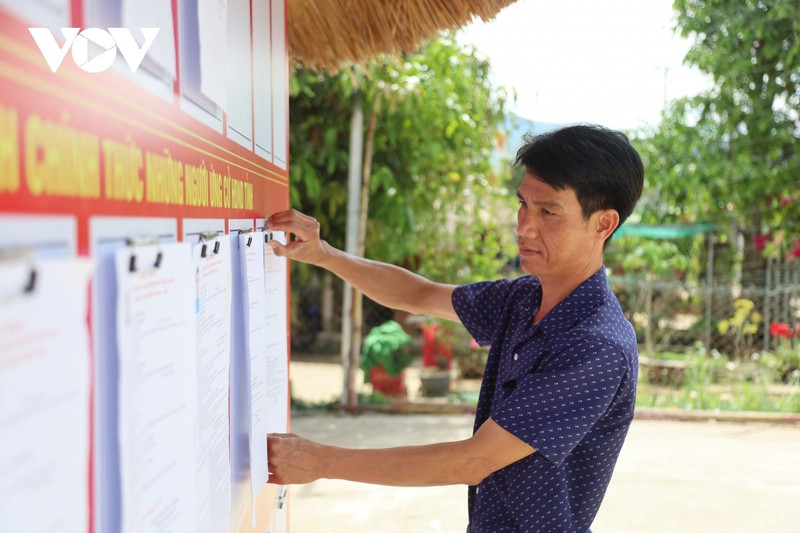 Des représentants de la commune de Duc Nong inspectent l'affichage de la liste des candidats. Photo : VOV.