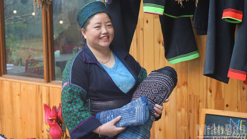 Sung Thi Lan, directrice de la Coopérative Muong Hoa, présente des produits traditionnels fabriqués par les femmes de la coopérative. Photo: NDEL