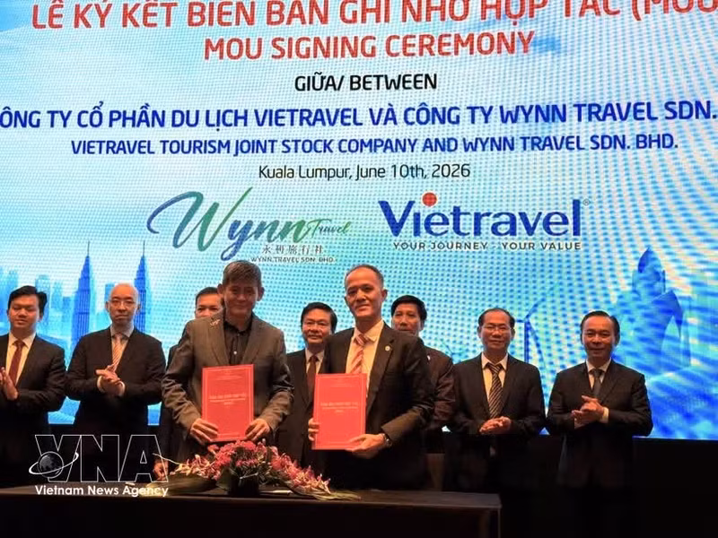 Des entreprises de voyage vietnamiennes et malaisiennes signent un accord de coopération lors de la conférence. Photo : VNA.