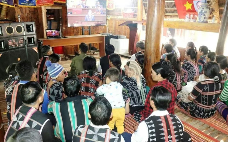 Des habitants de la commune frontalière d'A Vuong suivent la retransmission en direct de la séance d'ouverture du XIVe Congrès national du Parti à la maison Guol. Photo : VNA.