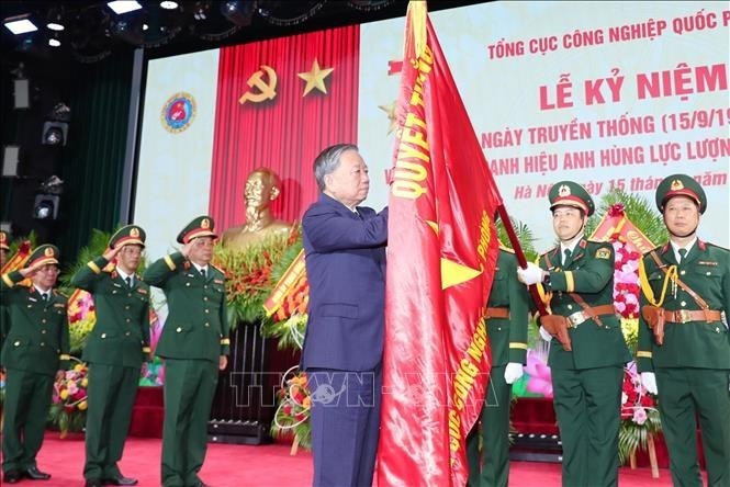 Le secrétaire général du Parti To Lam épingle l’insigne de Héros des Forces armées populaires sur le drapeau traditionnel du Département général de l’industrie de la défense. Photo : VNA.