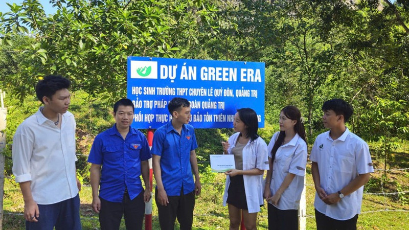 Quatre membres de l'équipe du projet Green Era ont fait un don et collaboré avec l'Union des jeunes de la réserve naturelle de Dakrong pour entretenir les vergers. Photo : Quang Huy.