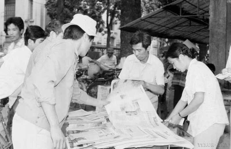 Des habitants de la capitale achètent le « Journal de l'après-midi » de VNA pour suivre les nouvelles de la clôture du 7e Congrès national du Parti (17 juillet 1991). Photo : VNA.