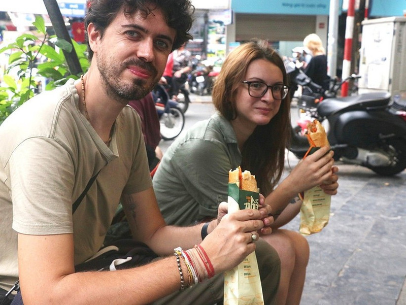 Des touristes dégustent du « bánh mì ». Photo: VNA