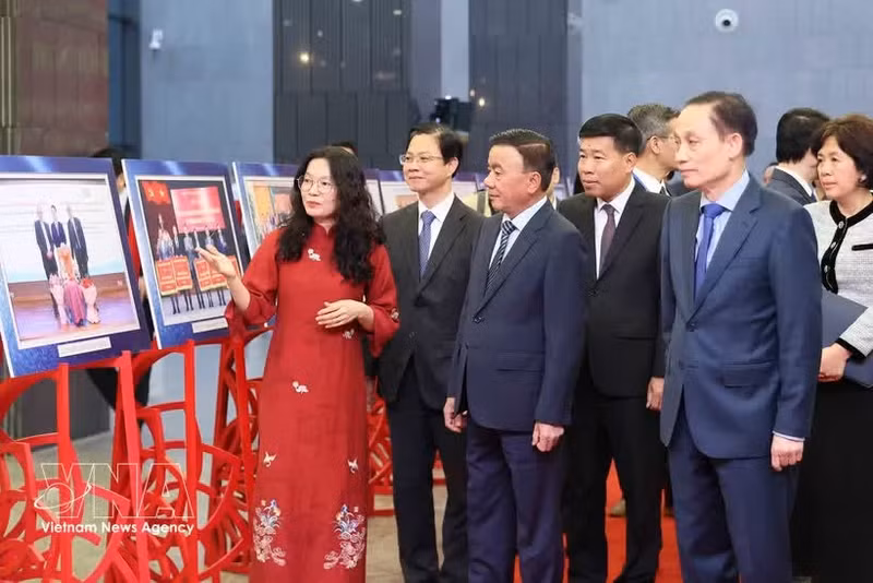 Le membre du Bureau politique, secrétaire du Comité central du Parti et permanent du Secrétariat du Comité central du Parti, Tran Cam Tu, avec des délégués lors de la visite de l’exposition de photos mettant en lumière les activités de relations extérieures populaires en 2025. Photo : VNA.