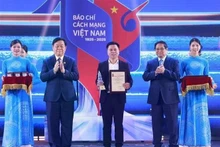 Le Premier ministre Pham Minh Chinh (deuxième, à droite) et le président de la Commission de l'information, de l'éducation et de la mobilisation de masse du Comité central du Parti, Nguyen Trong Nghia (deuxième à gauche), remettent un prix à un représentant des journalistes de VietnamPlus lors de la cérémonie du 21 juin. Photo : VNA. 