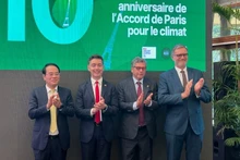 Des délégués lors de la conférence de presse pour célébrer le 10ᵉ anniversaire de la signature de l’Accord de Paris sur le climat, le 11 décembre à Hanoi. Photo : NDEL.
