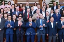 Le Premier ministre Pham Minh Chinh pose pour une photo souvenir avec les délégués lors de l'événement, à Hanoi, le 28 juin. Photo : VNA.