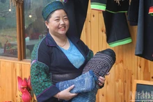 Sung Thi Lan, directrice de la Coopérative Muong Hoa, présente des produits traditionnels fabriqués par les femmes de la coopérative. Photo: NDEL