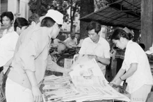 Des habitants de la capitale achètent le « Journal de l'après-midi » de VNA pour suivre les nouvelles de la clôture du 7e Congrès national du Parti (17 juillet 1991). Photo : VNA.