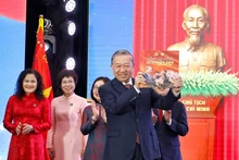 Le secrétaire général du Parti, To Lam, reçoit l’album photo « La gloire appartient à jamais au Peuple », offertpar l’Agence vietnamienne d’Information. Photo : VNA.
