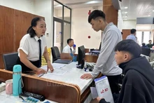 Le personnel du Centre de services administratifs publics du quartier de Tam Ky, dans la ville de Dà Nang, guide les gens dans les procédures administratives. Photo : VNA.