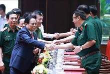 Le Premier ministre Pham Minh Chinh (à gauche) à la conférence politico-militaire de l'Armée. Photo : VNA.