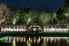 Effets lumineux projetés sur la surface des stèles en pierre et les motifs anciens, mettant en valeur les détails du patrimoine. Photo : VNA.