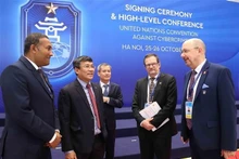 Le vice-ministre permanent vietnamien des Affaires étrangères Nguyen Minh Vu avec les délégués participant à la cérémonie de signature de la Convention de Hanoi le matin du 25 octobre. Photo : VNA.