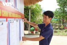 Des représentants de la commune de Duc Nong inspectent l'affichage de la liste des candidats. Photo : VOV.