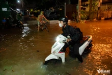 Dans la soirée du 7 novembre, la marée a atteint son troisième jour de crue du mois, entraînant l'inondation de nombreuses routes basses en bord de rivière à Ho Chi Minh-Ville. La situation est particulièrement grave dans la zone de la péninsule de Thanh Da – entourée par le fleuve Sai Gon – où le niveau de l'eau a tellement augmenté que plusieurs tronçons de la rue Binh Quoi étaient submergés jusqu'aux roues des véhicules. Photo: vietnamnet.vn