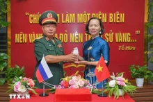 Le général Luu Trong Lu, président de l’Association des anciens combattants de la province de Dien Bien, remet l’urne contenant la terre sacrée à Vu Thi Tuyet Nga, directrice du Musée de la Victoire de Diên Biên Phu. Photo : VNA.